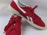 a pair of red sneakers with white laces on them