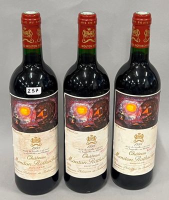 three bottles of red wine sitting next to each other on a table