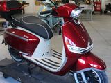 un scooter rouge et blanc garé dans un garage