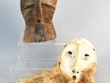deux masques et un cheveu exposés dans une boîte transparente