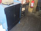 a blue cabinet with a black door and a red fire hydrant in the background