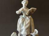 a statue of a woman on top of a pile of figurines