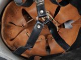 a close up of a helmet with a leather strap on it