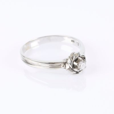 a white gold ring with a single diamond in the center