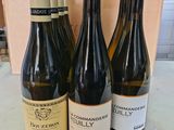 trois bouteilles de vin sont posées sur une table devant une boîte