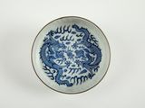 une assiette bleue et blanche ornée d'un motif représentant un dragon