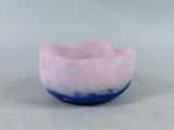 un bol rose et bleu posé sur une surface blanche