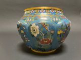 a blue vase with a bird and flowers on it