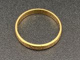 gros plan d'une bague en or sur une surface noire