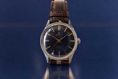 an image of a watch sitting on top of a blue surface