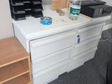 a white desk with drawers and a bottle of water on it