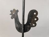 a metal sculpture of a rooster on a stand