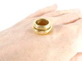a person ' s hand holding a gold ring with a diamond on it