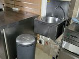 an image of a kitchen with a sink and a trash can