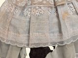 a doll that is wearing a dress with laces on it