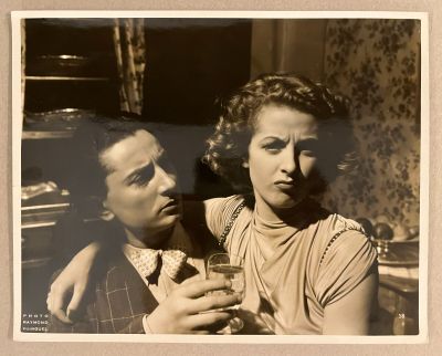 une vieille photo d'un homme et d'une femme tenant des verres à vin