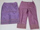deux paires de pantalons violets posées sur une table blanche