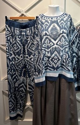 deux vêtements pour femmes présentés sur un mannequin dans une boutique