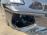 a close up of a car ' s front bumper with a person taking a picture of it
