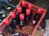 many bottles of soda in a red basket on the floor