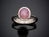 Gros plan sur une bague ornée d'une pierre rose