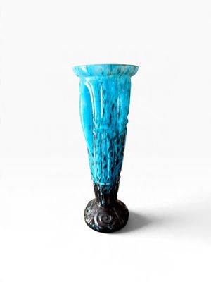 a blue glass vase with a black base on a white background
