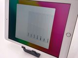 tablet computer sitting on top of a white table with a colorful screen