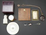 a table with a box, a plate, spoon, and other items on it