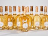 six bouteilles de vin sont alignées sur une surface blanche