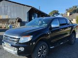 a picture of a black pickup truck parked in front of a barn