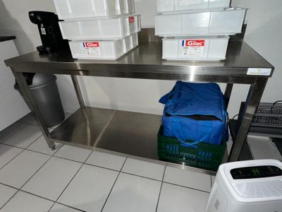 une table en acier inoxydable surmontée de deux bacs