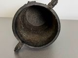 a small metal object sitting on top of a table next to a white wall