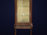 an antique wooden display cabinet with glass doors and a marble top