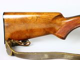 a close up of a rifle on a white background with a brown strap
