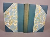 un livre ouvert avec une couverture bleue et un marque-page vert