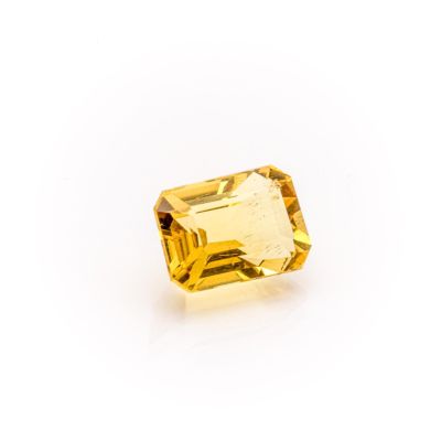 a yellow sapphire stone on a white background