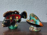 two fish figurines sitting on a table next to each other