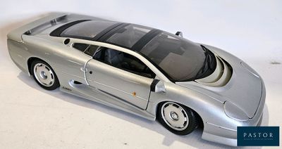 une maquette argentée d'une voiture de sport posée sur une surface blanche