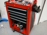 une boîte à outils rouge sur laquelle sont posés des outils, dans un garage