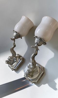 paire de lampes plaquées argent avec des abat-jours blancs, posées sur un support blanc