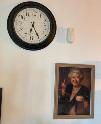 une horloge accrochée au mur au-dessus d'un portrait de femme