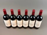 six bottles of red wine lined up in a row