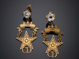 une paire de boucles d'oreilles en or ornées d'une étoile et d'un ruban