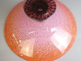 un vase rose et orange posé sur une table blanche
