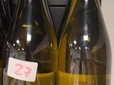 trois bouteilles de vin posées sur une étagère dans un magasin