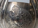 a silver vase with a label on it on a table