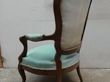 une chaise sur laquelle est posé un coussin bleu, devant un mur blanc