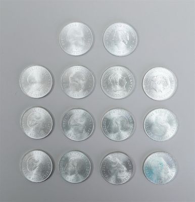 a group of twenty silver coins arranged in a circle