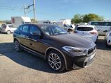 the bmw x2 is parked in a lot with other cars in the background