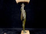 statue of a woman with a bowl on her head on a wooden base